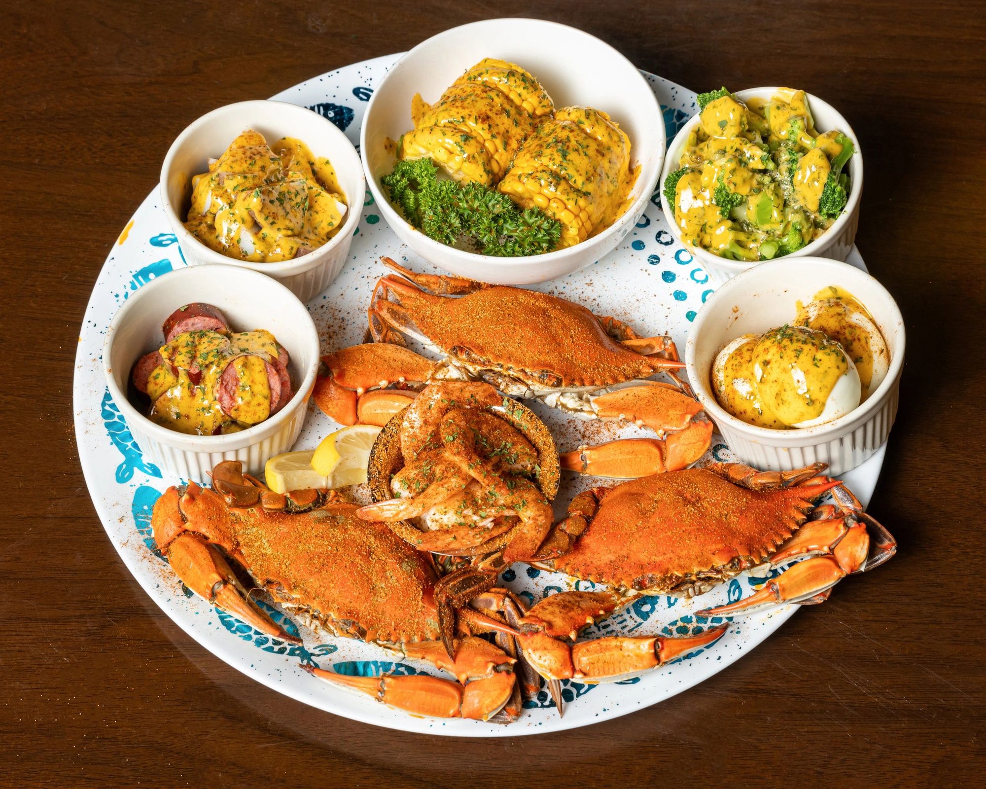 The Blue Crab Specialty Tray: blue crabs with bowls of corn, potatoes, shrimp and sides
