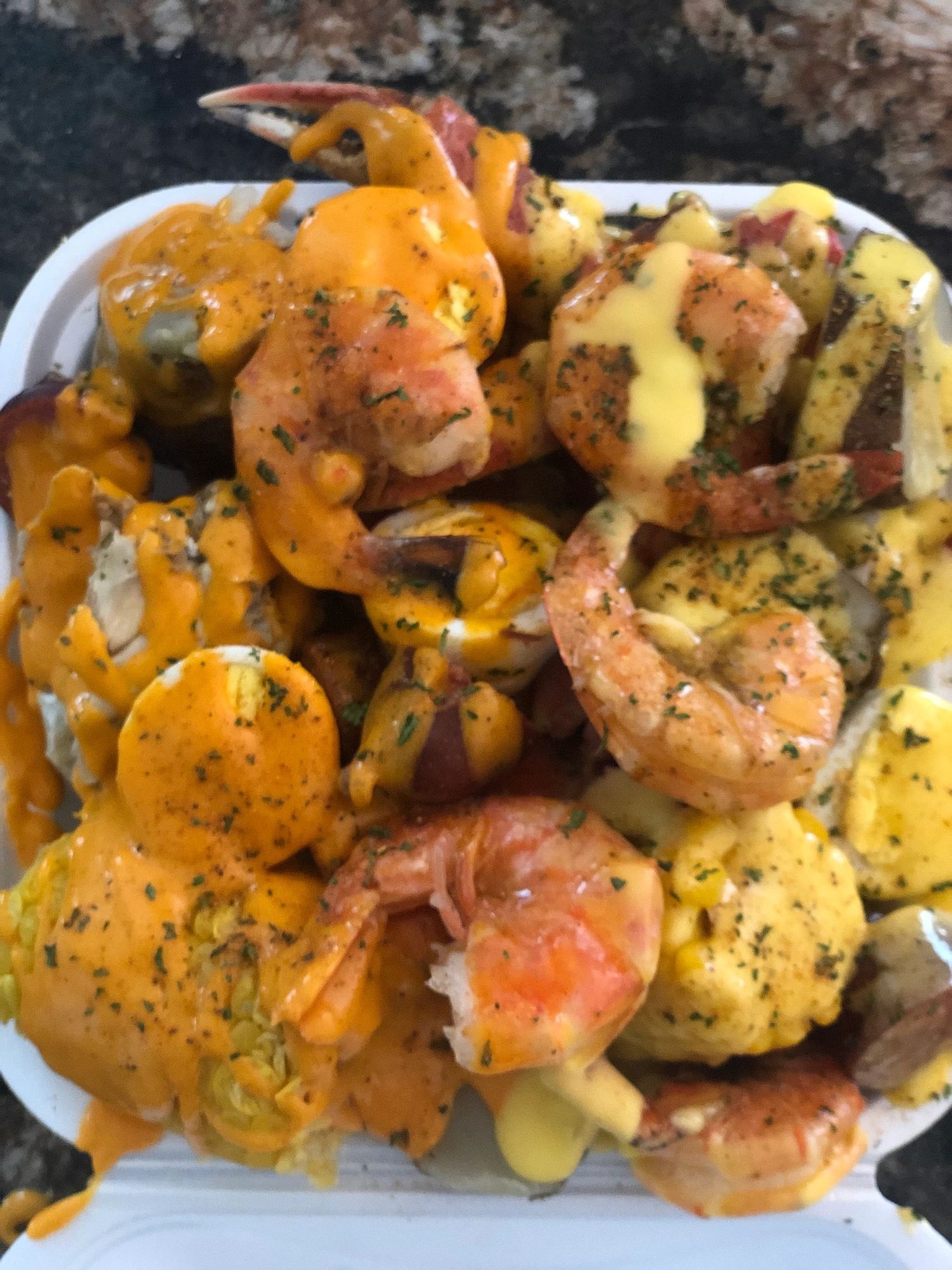 A tray of shrimp, potatoes and corn in Trap Butter