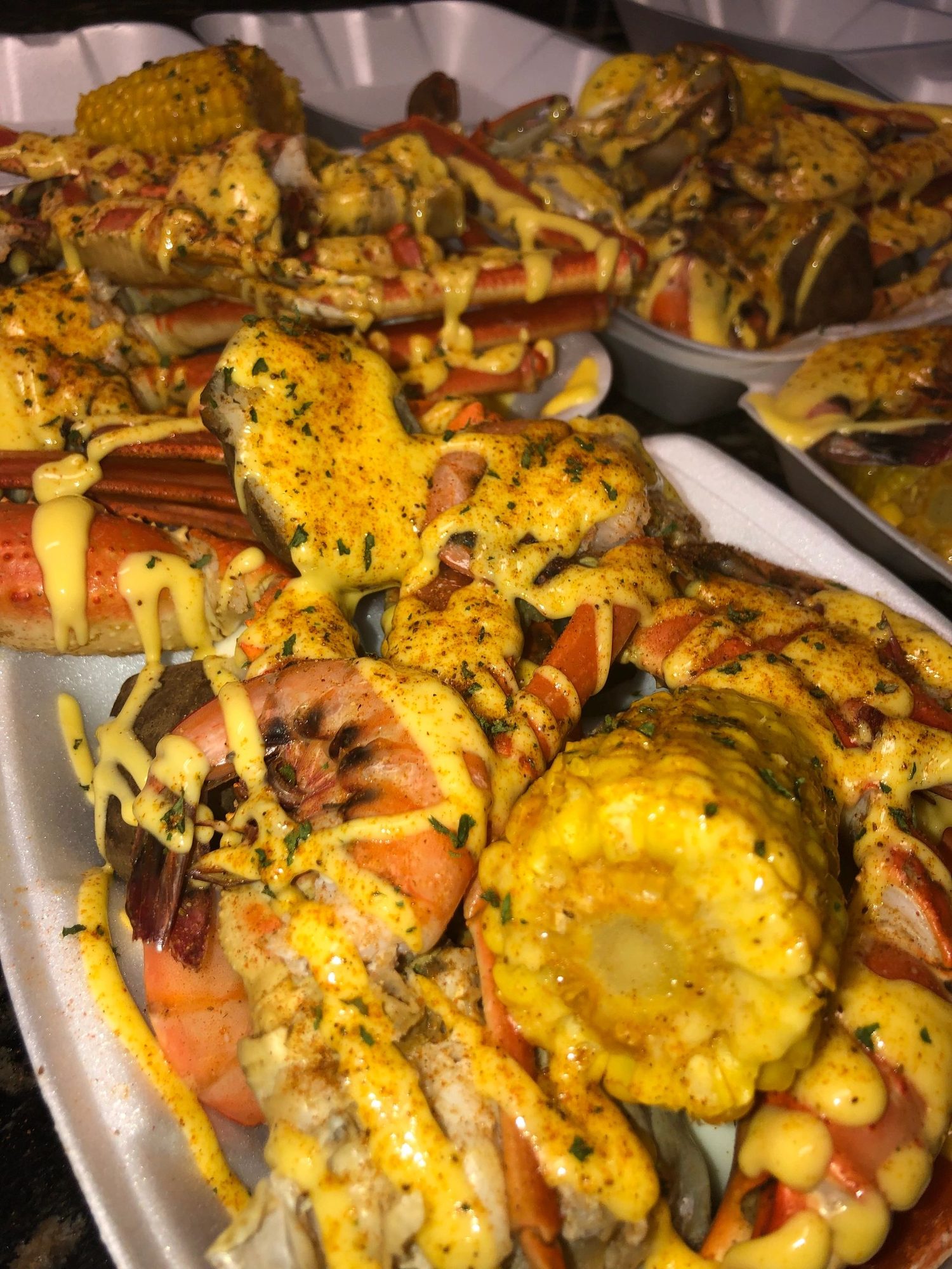 A takeout tray of crab, shrimp and corn